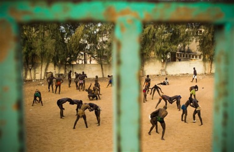 Young men who attend the Ecurie Dakar Plateau school for traditional Senegalese wrestling train in a schoolyard in Dakar, Senegal. Thousands of unemployed or underemployed men flock to this West African country's capital to train in wrestling schools in the hopes of making it big. 